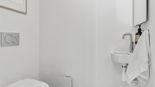 Praktisk toalettrom fra byggeår med adkomst fra entré. Gulvflate belagt med en-stavs parkett.