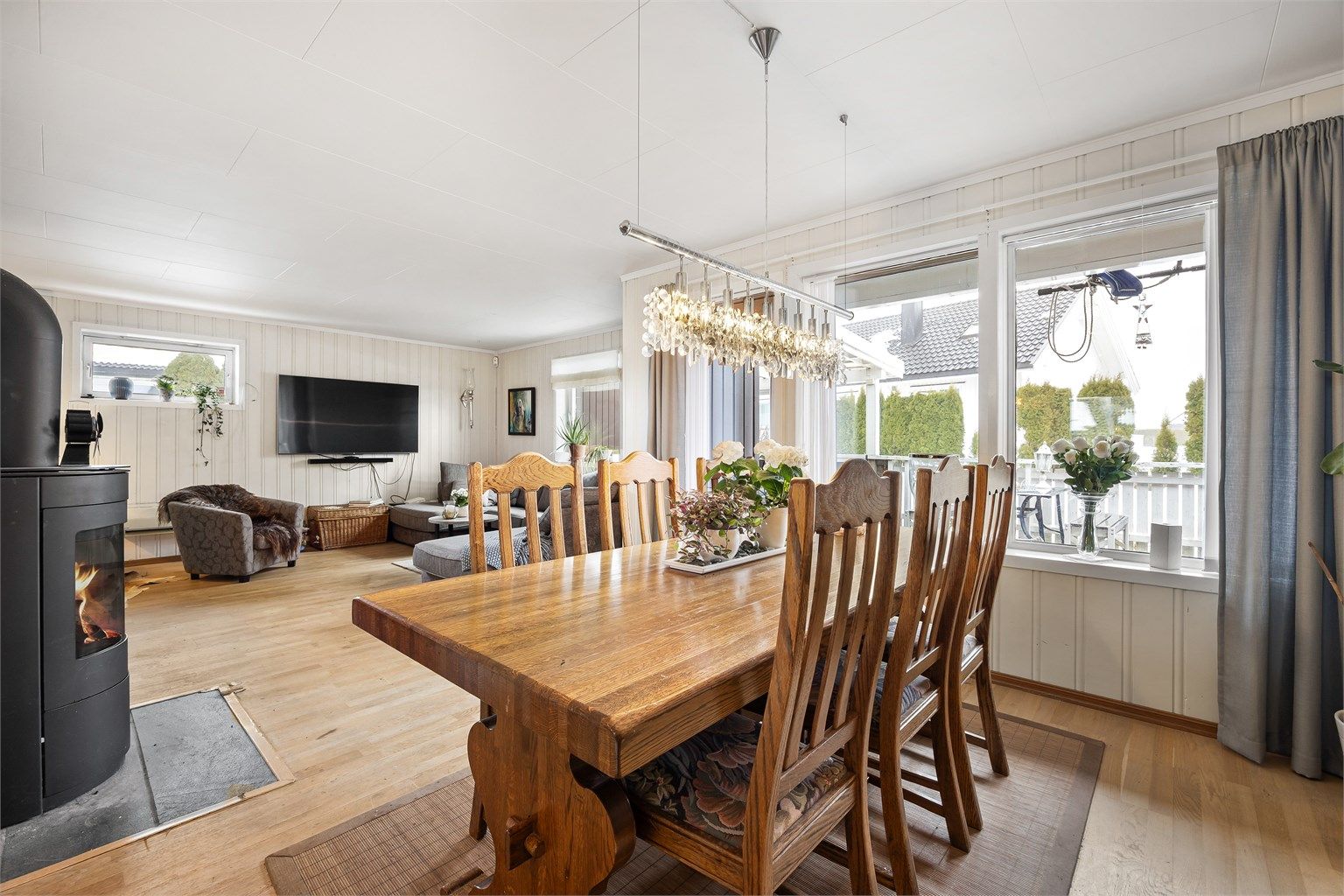 Lys vinkelstue med sofaområde og spiseplass.