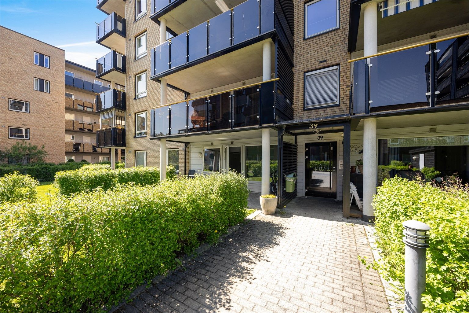 Hyggelig inngangsparti til blokken med callinganlegg for leilighetene