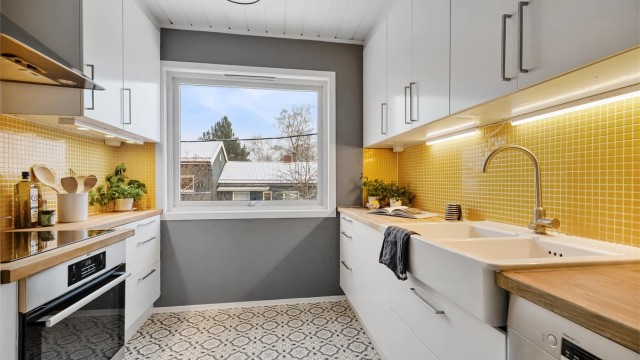 Kjøkkenet er praktisk innredet med glatte fronter, benkeplate i tre og integrerte hvitevarer.