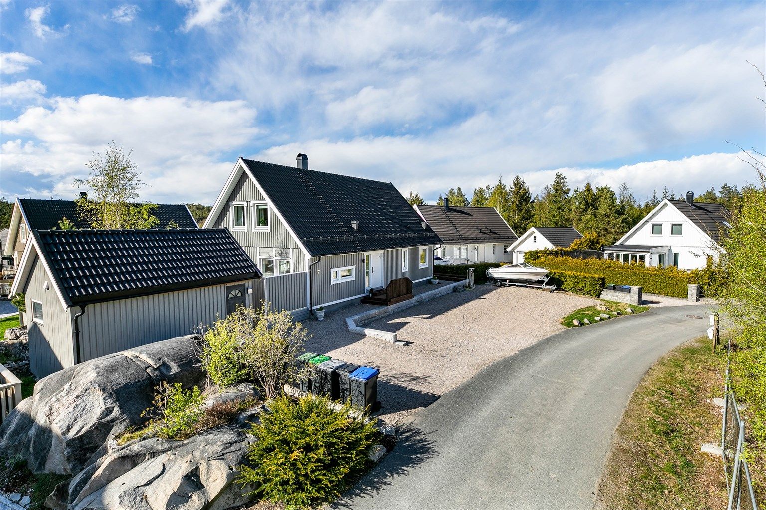 På den grusede gårdsplassen er det oppstillingsmulighet for flere biler, tilhenger og båt i vinteropplag.