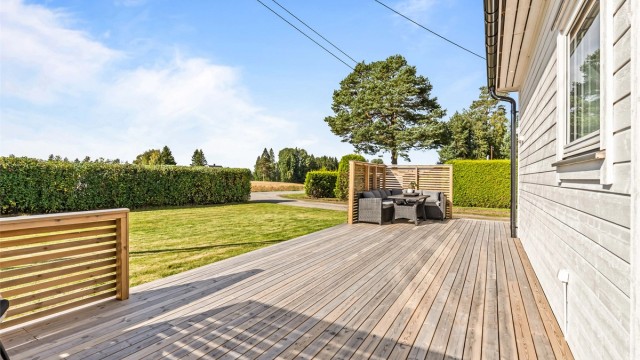 Solrik terrasse med god plass til utemøbler og åpen overgang til hagen.
