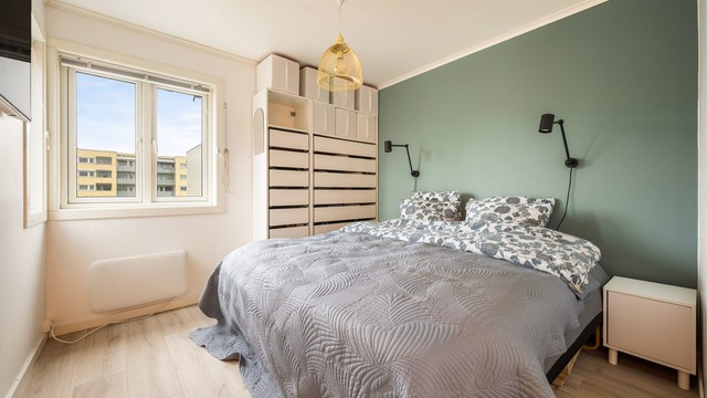 Hovedsoverommet har god plass til dobbeltseng og romslig garderobe, og den dype grønne aksentveggen gir rommet en rolig og lun atmosfære.