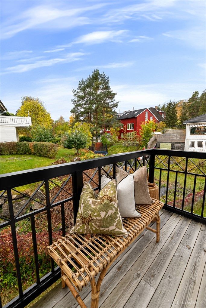 Balkong i 2. etasje med tremmegulv og smijernsrekkverk, med utgang fra hovedsoverommet.
