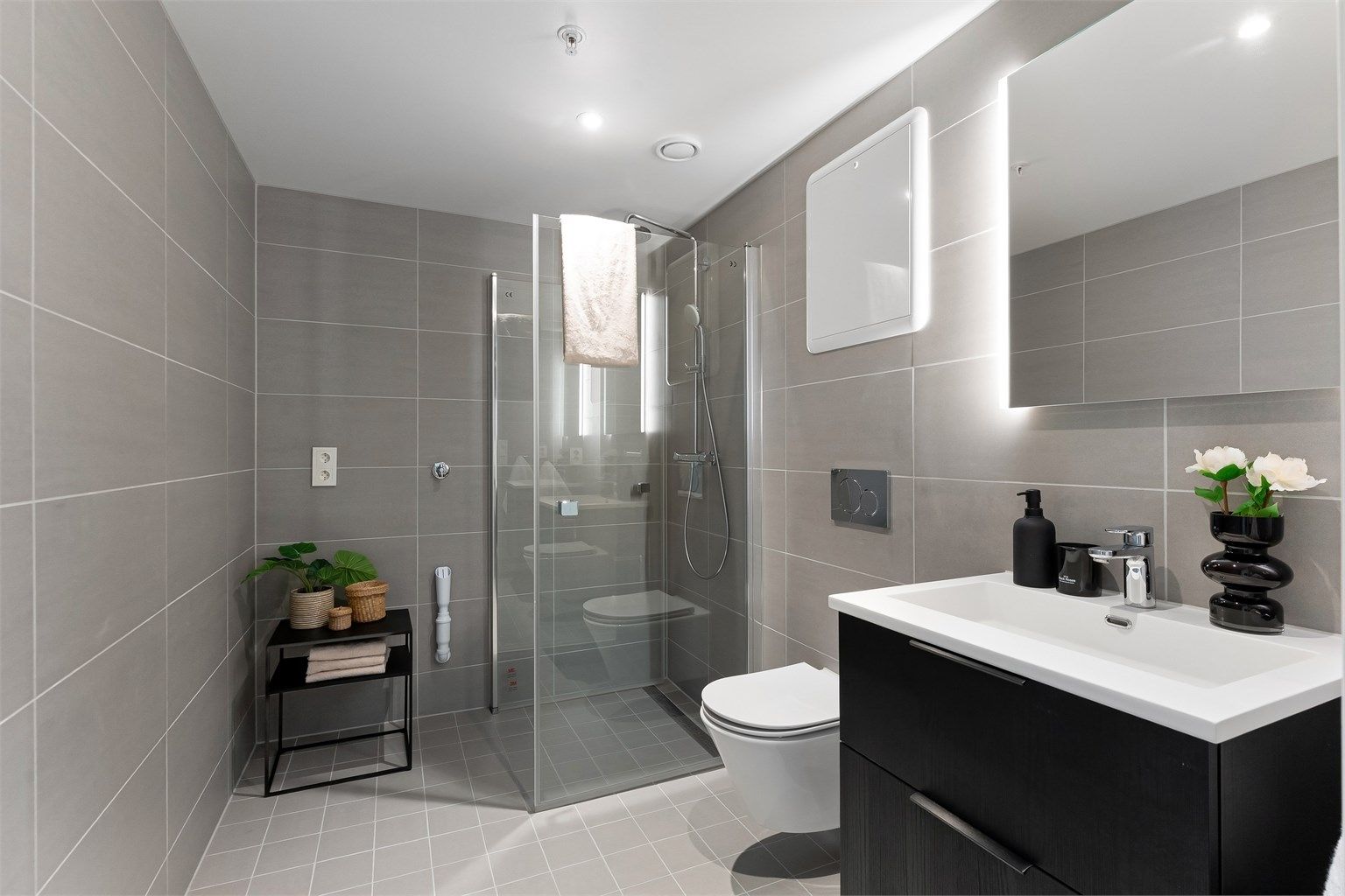 Pent og flislagt baderom med gulvvarme, downlights og opplegg for vaskemaskin og tørketrommel. Regnfallsdusj