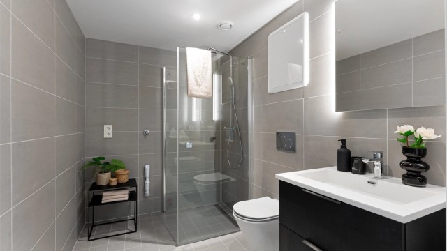 Pent og flislagt baderom med gulvvarme, downlights og opplegg for vaskemaskin og tørketrommel. Regnfallsdusj