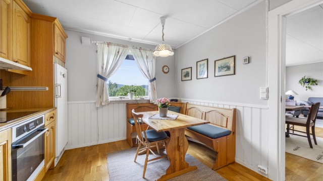 En hyggelig spiseplass ved vinduet med utsikt mot hagen og vannet.