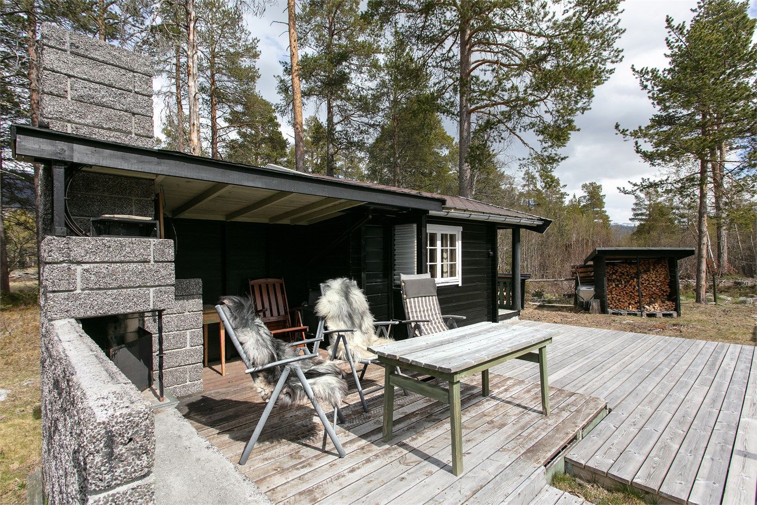I tilknytning til annekset er det en overbygget utestue med murt utepeis.