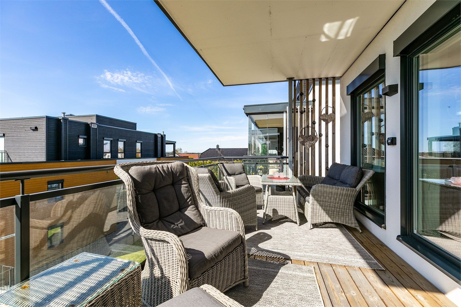 Verandaen er pent innrammet av rekkverk med glass som ivaretar både utsikten og de meget gode solforholdene.