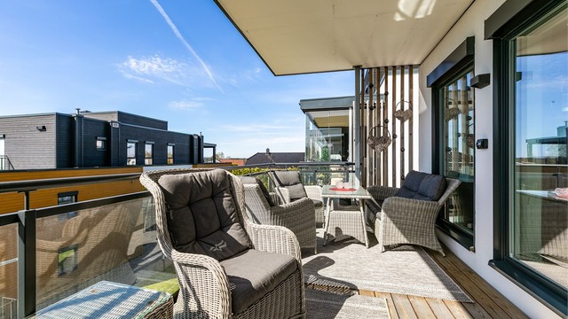 Verandaen er pent innrammet av rekkverk med glass som ivaretar både utsikten og de meget gode solforholdene.