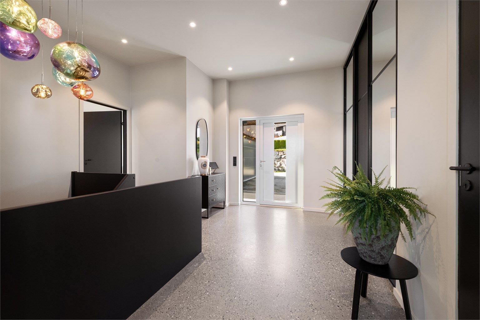 Romslig entré/hall/trapperom med slipt betonggulv, gulvvarme og innfelte downlights.