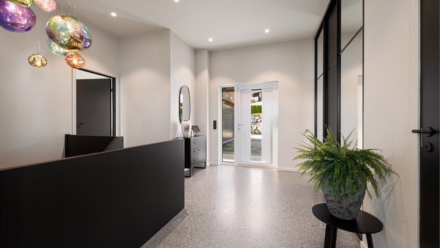 Romslig entré/hall/trapperom med slipt betonggulv, gulvvarme og innfelte downlights.