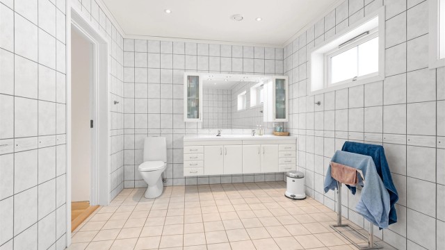 Innredningen har doble servanter og rikelig med oppbevaringsplass i skuffer og skap.