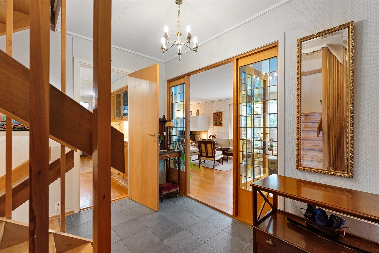 Dører med glassfelt åpner fra gangen inn mot stuen og slipper lyset gjennom.