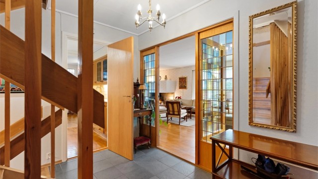 Dører med glassfelt åpner fra gangen inn mot stuen og slipper lyset gjennom.