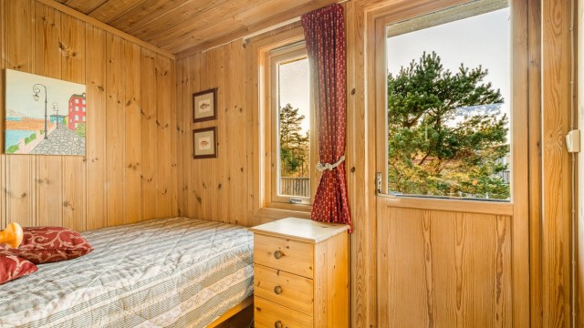 Det andre soverommet har enkeltseng og direkte utgang til terrassen bak hytta.