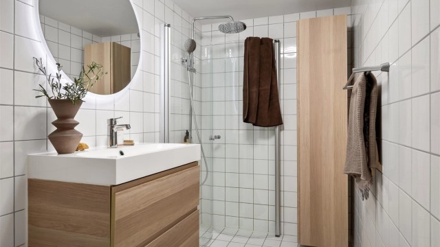 Badet er utstyrt med vegghengt toalett og dusjhjørne med innfellbare glassdører, og dusjsett med rainshower