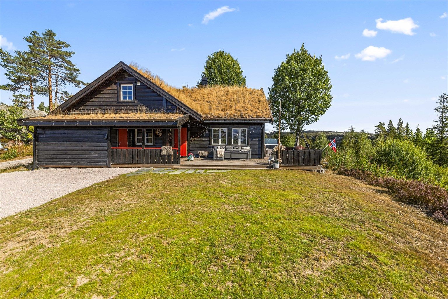 Hytta sett fra adkomsten, med torvtak og liggende trekledning. Foto: [Fotograf Magik]