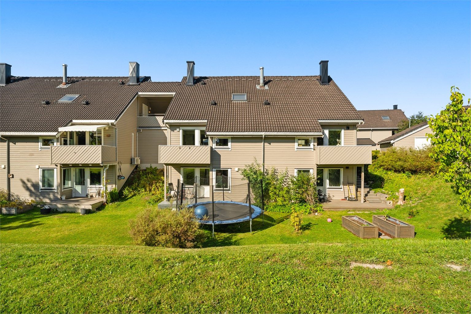 Boligen ligger i et rolig og familievennlig område med grøntområder rett utenfor.
Foto: [Fotograf eller fotofirma]