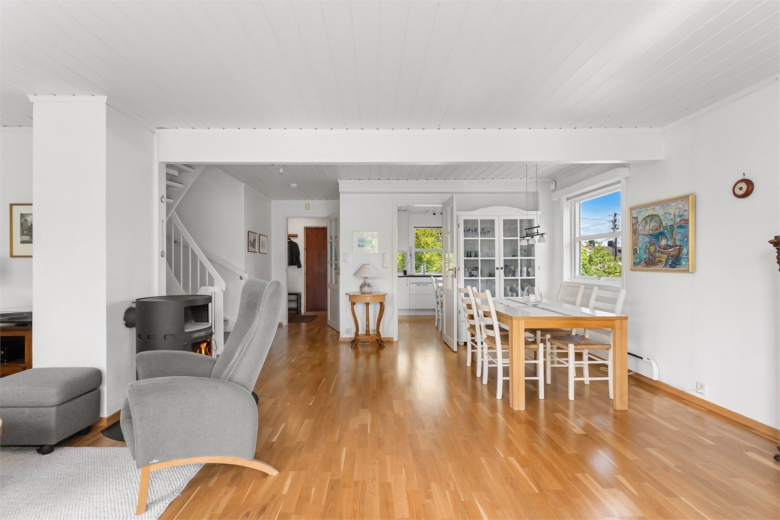 Stuen i første etasje har plass til både sofagruppe og spisebord, med gjennomgående parkett på gulvet.