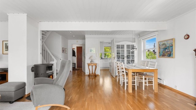 Stuen i første etasje har plass til både sofagruppe og spisebord, med gjennomgående parkett på gulvet.