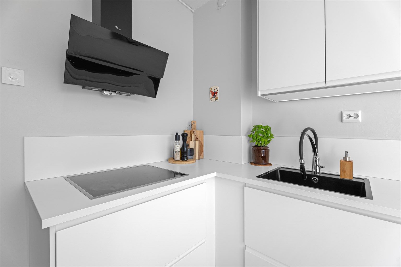 Kjøkkeninnredning med glatte fronter og benkeplate med laminert overflate gir et rent og moderne inntrykk.