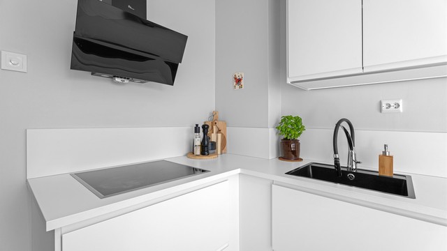 Kjøkkeninnredning med glatte fronter og benkeplate med laminert overflate gir et rent og moderne inntrykk.