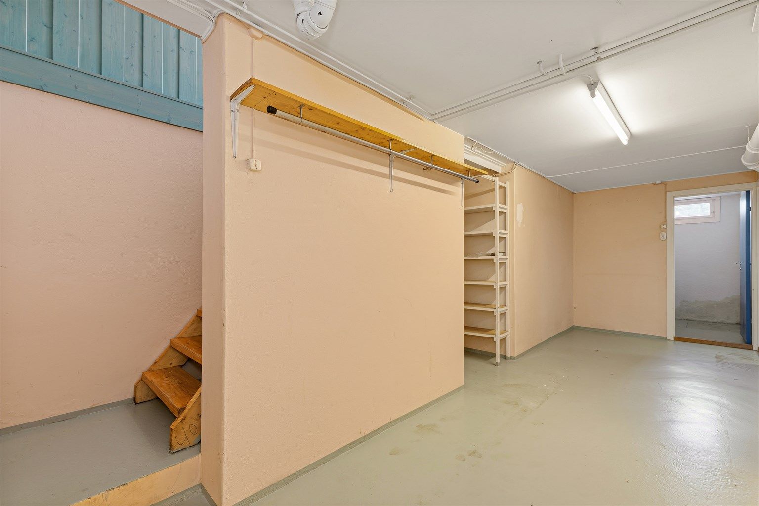 Trappegang i kjeller med adkomst til matbod, vaskerom, bodrom og utgravet kjellerrom.