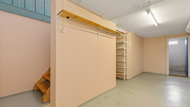 Trappegang i kjeller med adkomst til matbod, vaskerom, bodrom og utgravet kjellerrom.