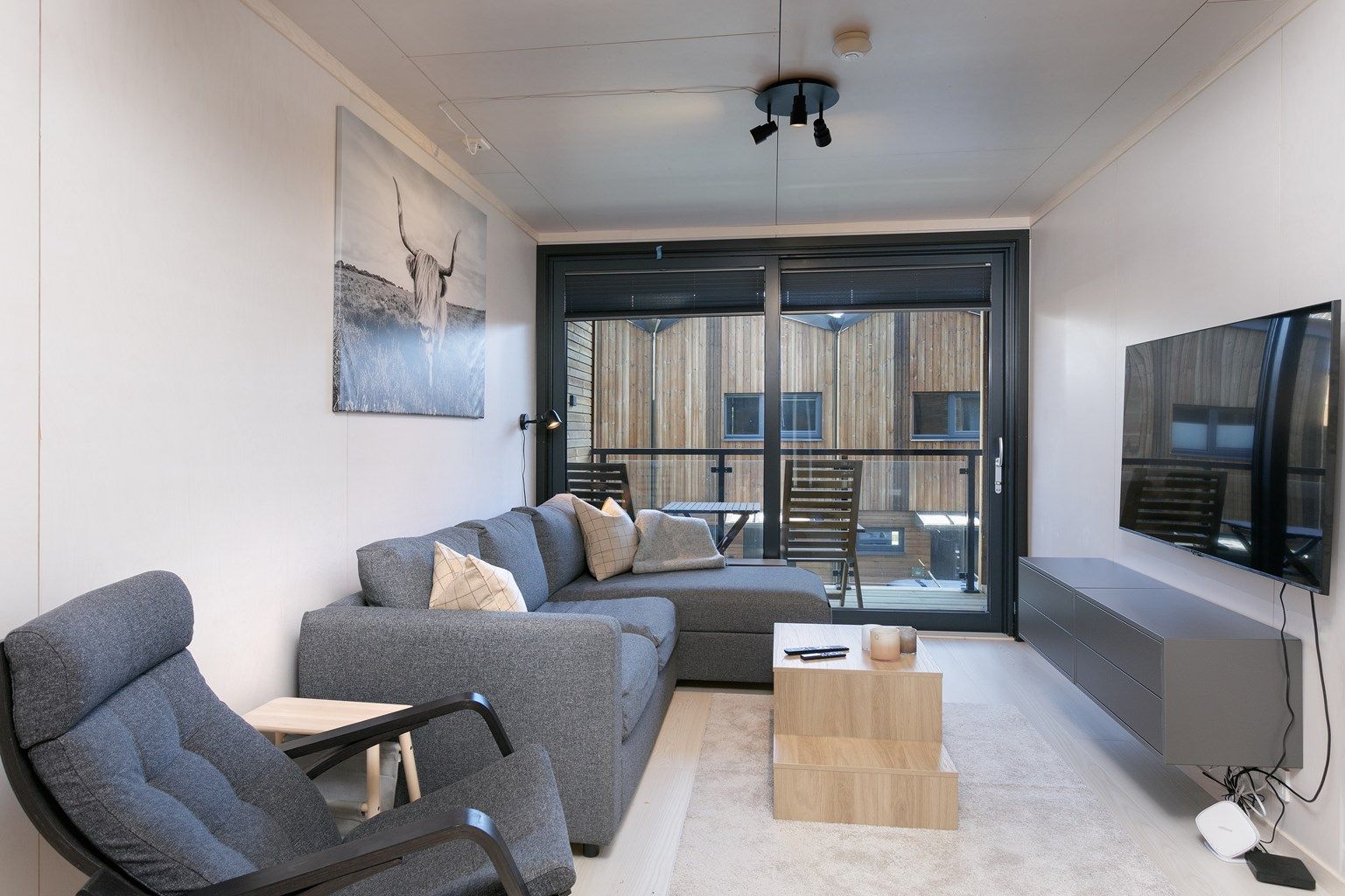 Det er utgang fra stue til inntrukket balkong med glassrekkverk