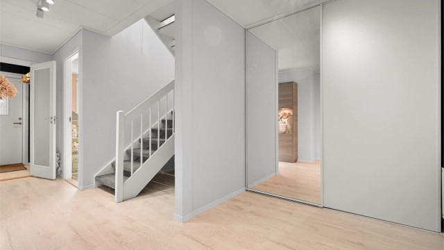 Romslig gang/hall i 1. etasje med stor skyvedørsgarderobe.