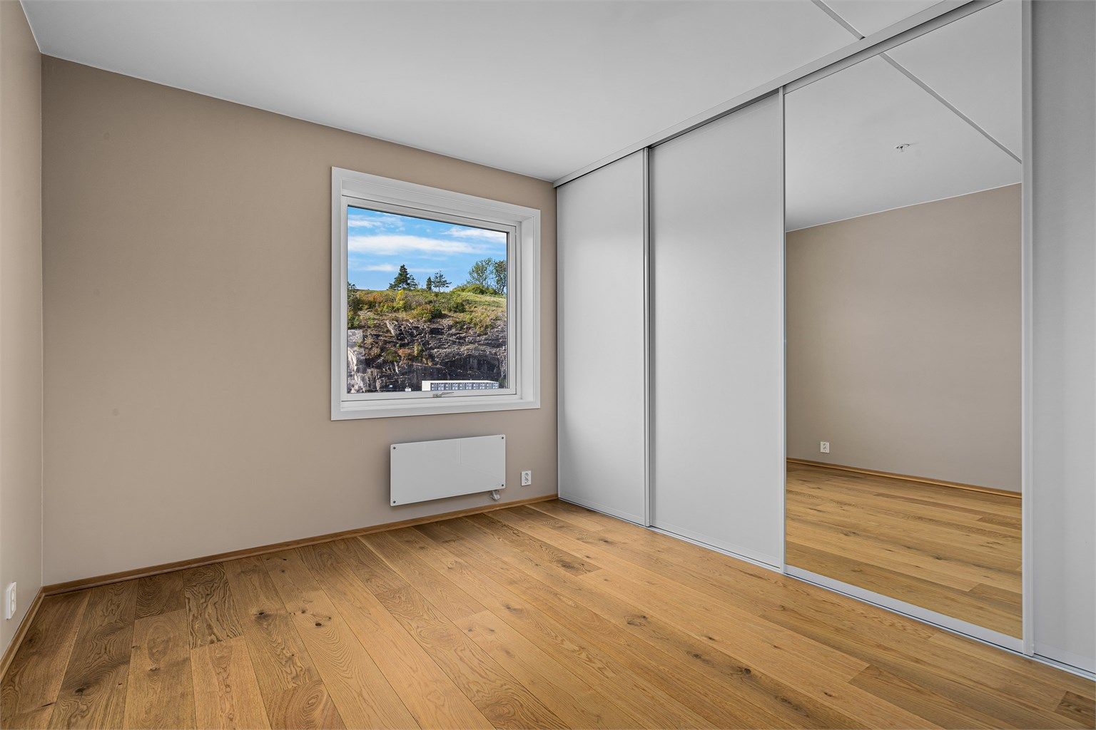 Romslig soverom med stor skyvedørsgarderobe.