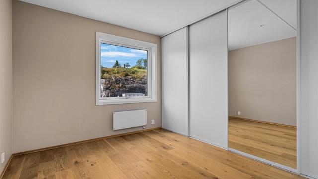 Romslig soverom med stor skyvedørsgarderobe.