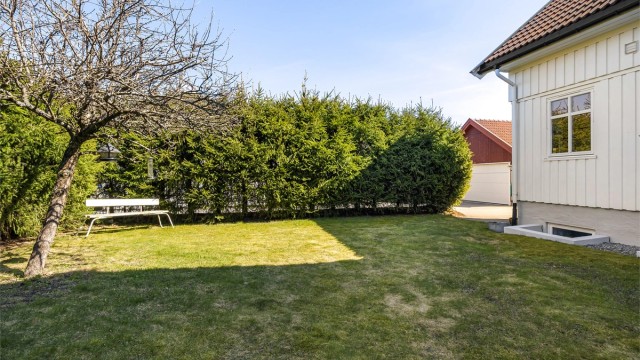 Hagen er pent opparbeidet med plenarealer og beplantning som skaper en privat og lun atmosfære.