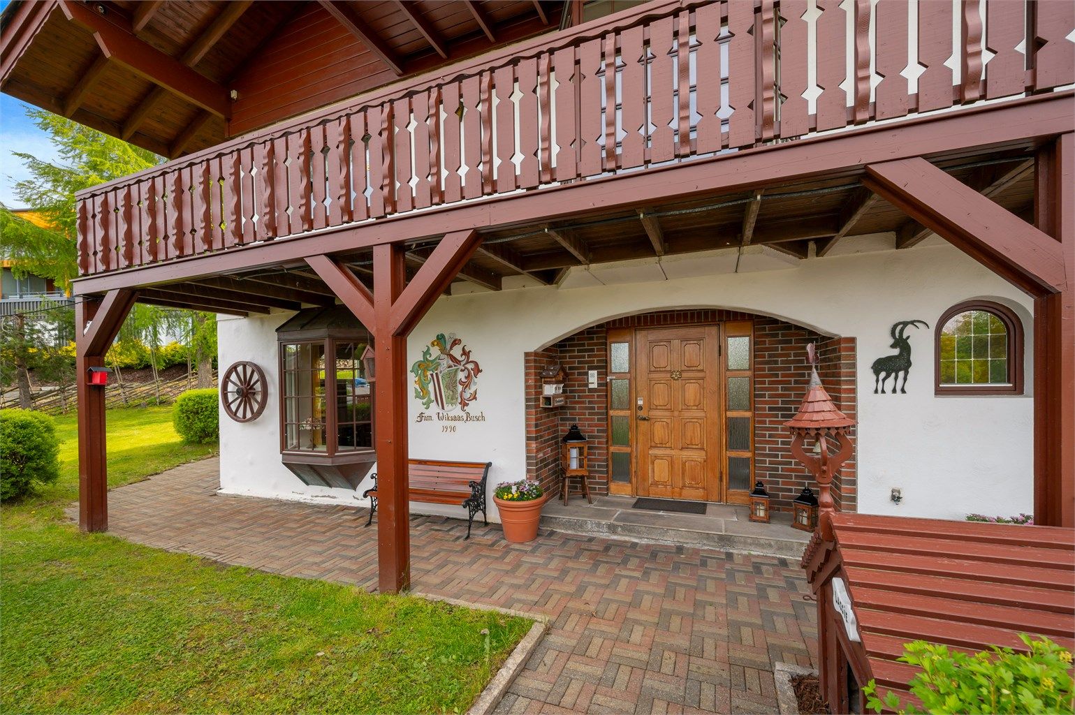 Flott, herskapelig inngangsparti med selvlaget familievåpen på veggen. 