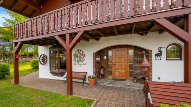 Flott, herskapelig inngangsparti med selvlaget familievåpen på veggen.