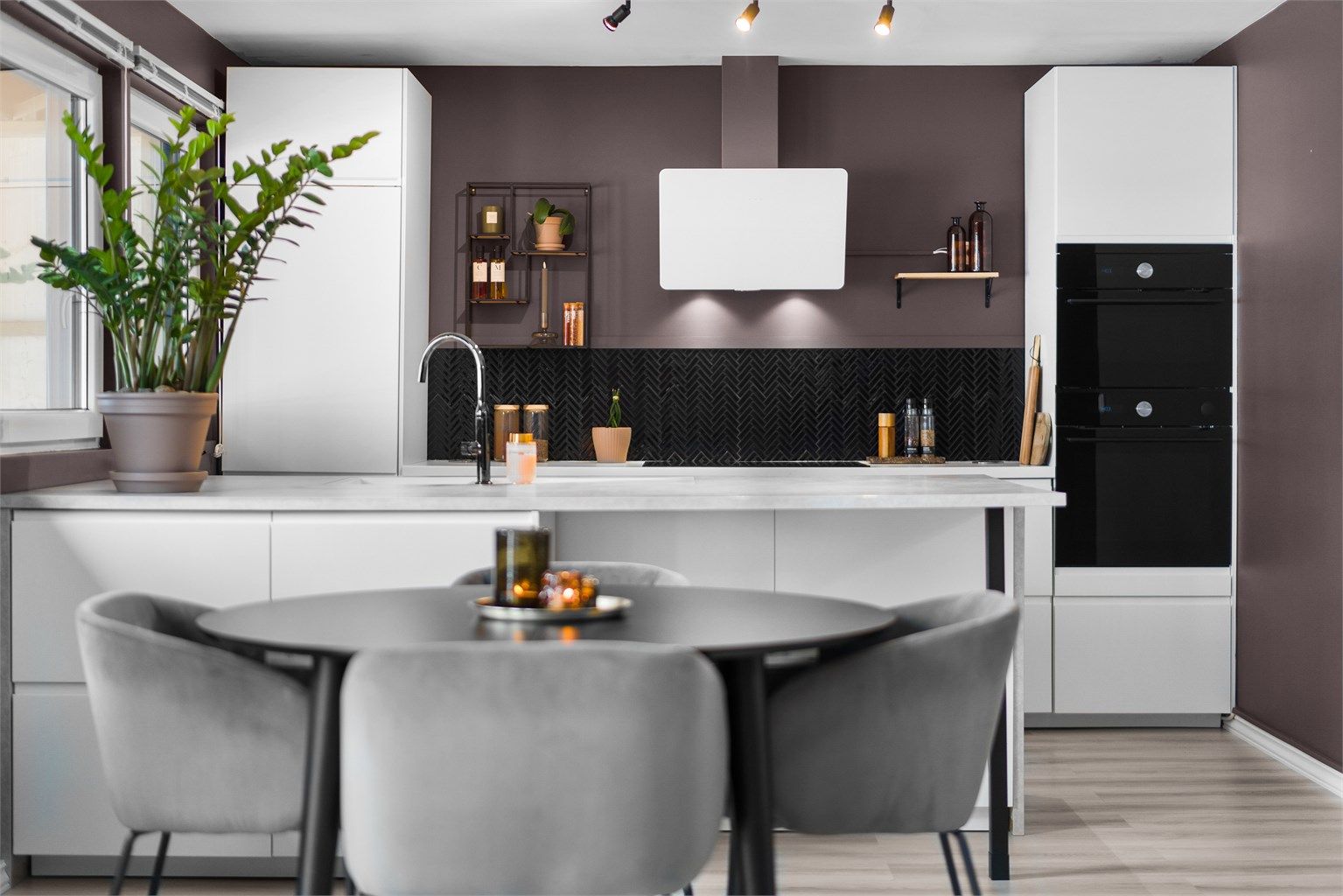 Pent kjøkken fra 2021 med glatte fronter, laminerte benkeplate med integrerte stikkontakter og planlimt oppvaskkum i kompositt med ettgreps armatur.