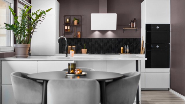 Pent kjøkken fra 2021 med glatte fronter, laminerte benkeplate med integrerte stikkontakter og planlimt oppvaskkum i kompositt med ettgreps armatur.