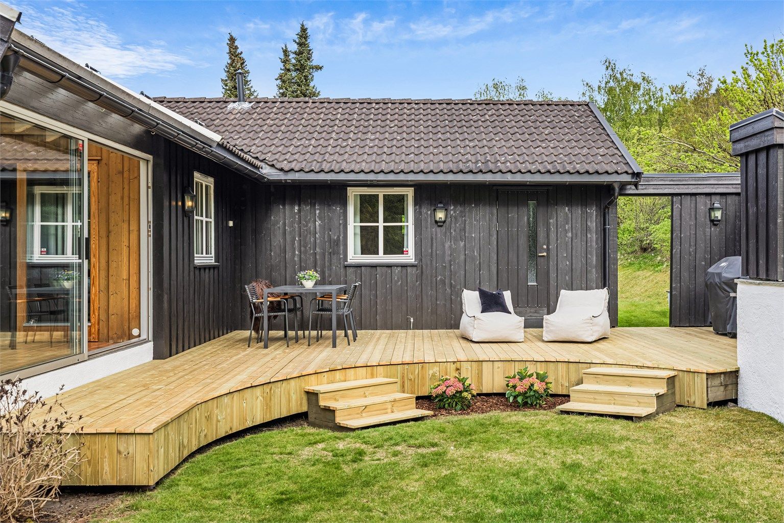 Den buede formen på terrassen skaper et mykt og innbydende uterom.