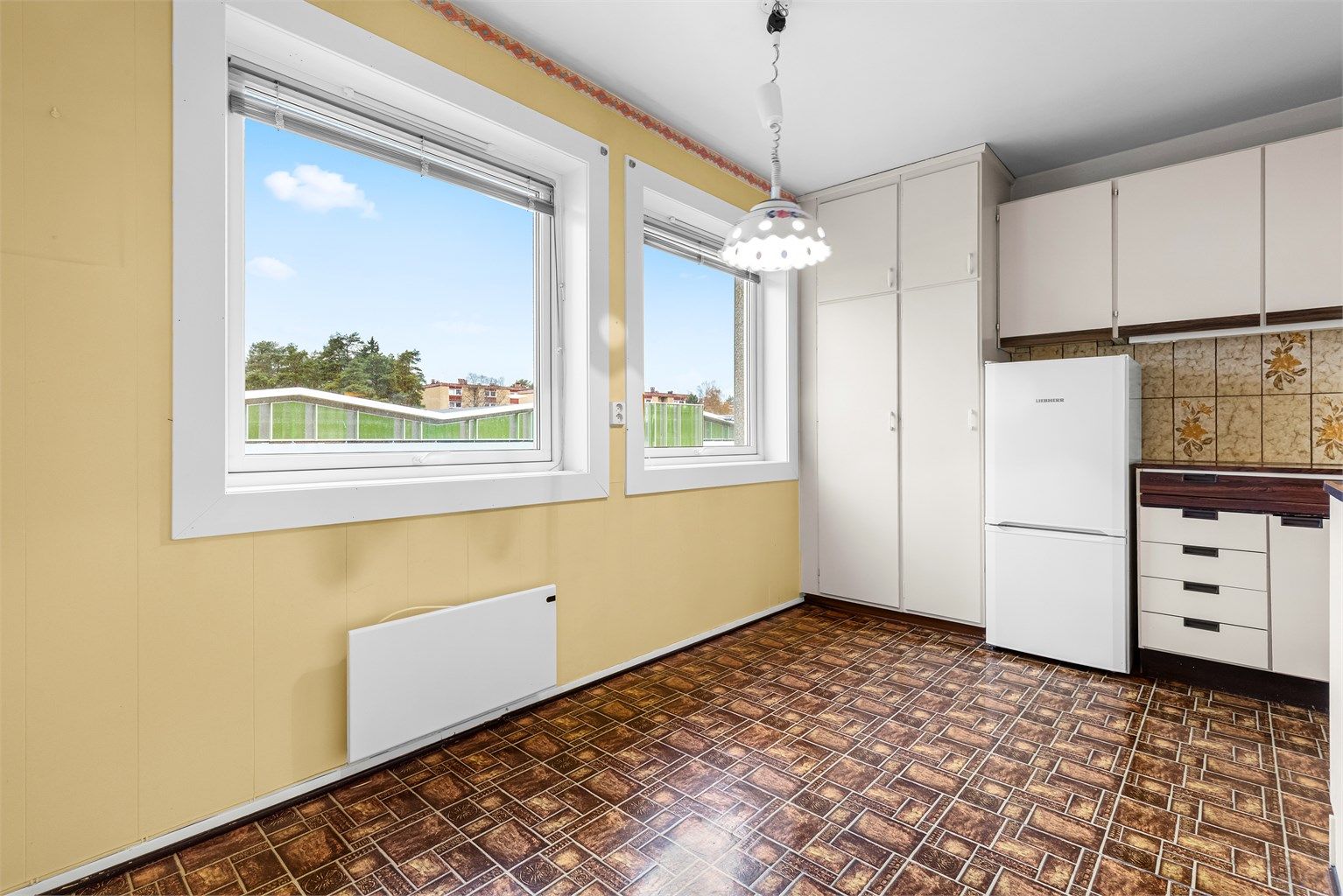 Kjøkkenet er et separat rom med plass til en spiseplass ved vinduet.