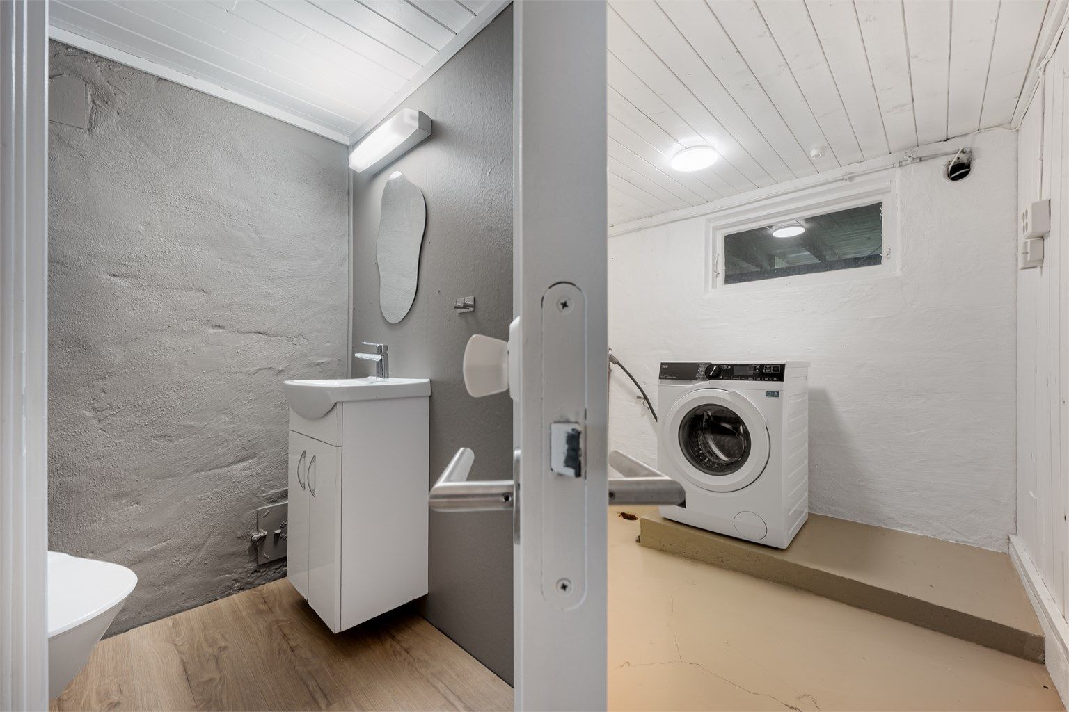 Wc har malte betongvegger, laminat på gulv, enkel servant. Vaskerom er av god størrelse med god plass til vaskemaskin samt tørketrommel. 
Det er malt betonggulv, vegger i betong. 