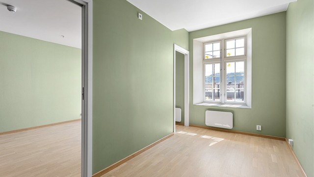 Leiligheten har et romslig soverom, plassert ved siden av stuen.