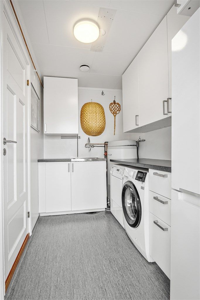 Separat vaskerom med innredning, utslagsvask og opplegg for vaskemaskin samt tørketrommel under benk.