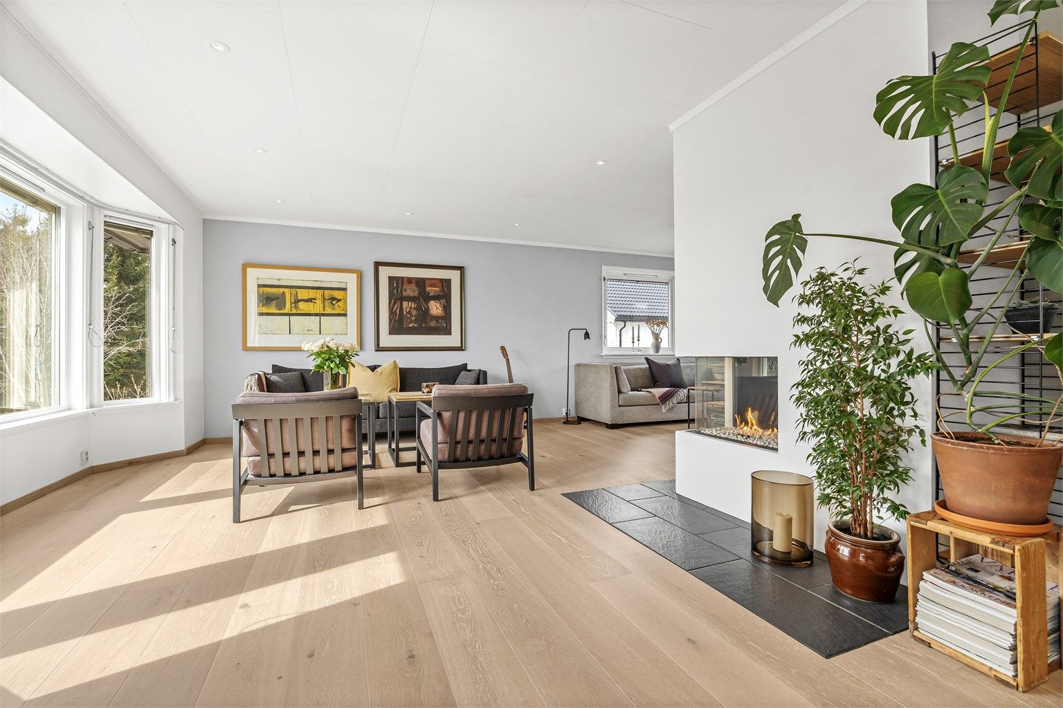 Stuen har en åpen løsning mot kjøkkenet, noe som skaper en sosial og luftig sone.