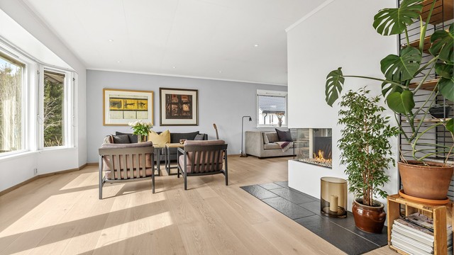 Stuen har en åpen løsning mot kjøkkenet, noe som skaper en sosial og luftig sone.