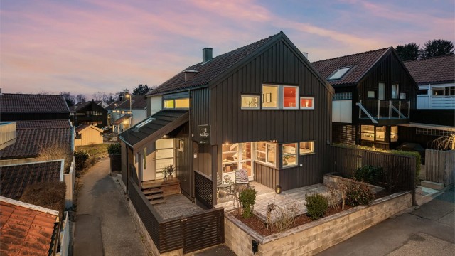 Parkering på felles område foran inngangsparti. Her er det montert el-bil lader. Terrasse ved inngangsparti.