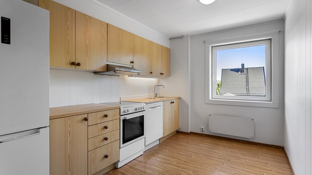 Kjøkkenet i underetasjen har laminert benkeplate, ventilator i overskap og benkebelysning.