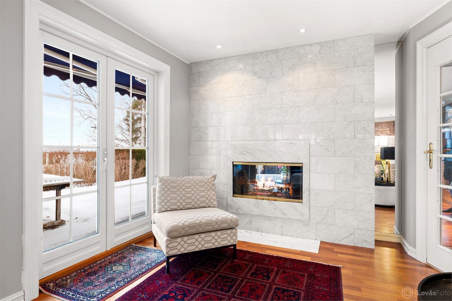 Gjennomgående peis mellom stue og kjøkken med glassdører, for ekstra hygge og varme