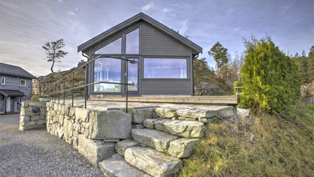 Flott steinmur, smijernsrekkverk og usjenert hage - Det er montert elbillader
som medfølger salget