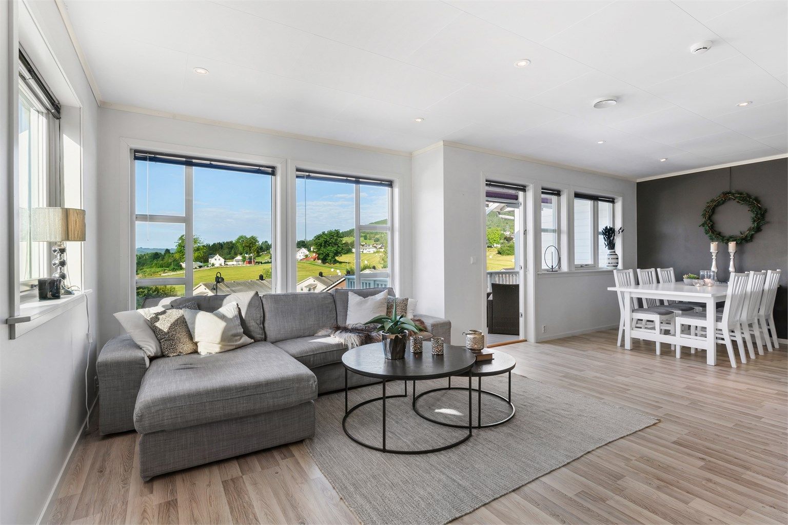 Rommet har store vindusflater i flere himmelretninger, som slipper mye naturlig lys inn i rommet og gir en sjarmerende utsikt